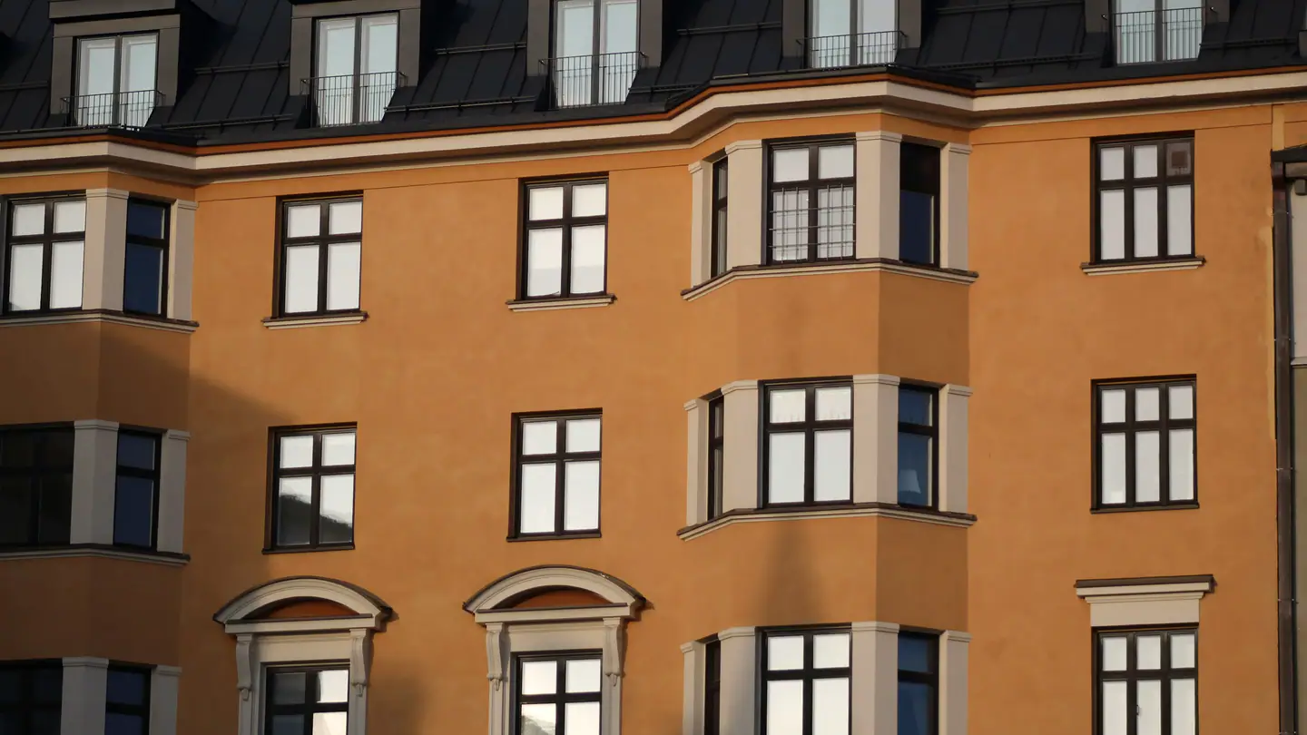 Ockerfarbene Altbaufassade mit hellen Erkern und Mansarddach