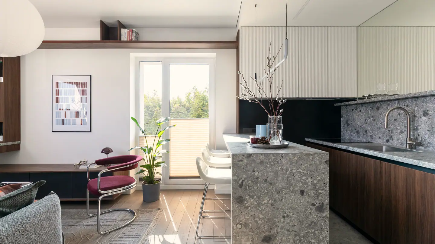 Offene Küche mit Terrazzo-Insel, dahinter die Tür nach draußen