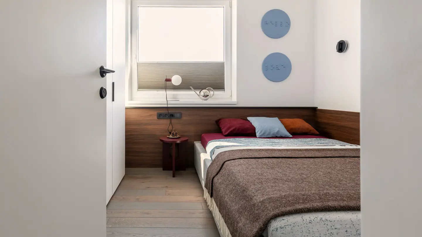 Schmales Schlafzimmer, das Bett unter dem Fenster