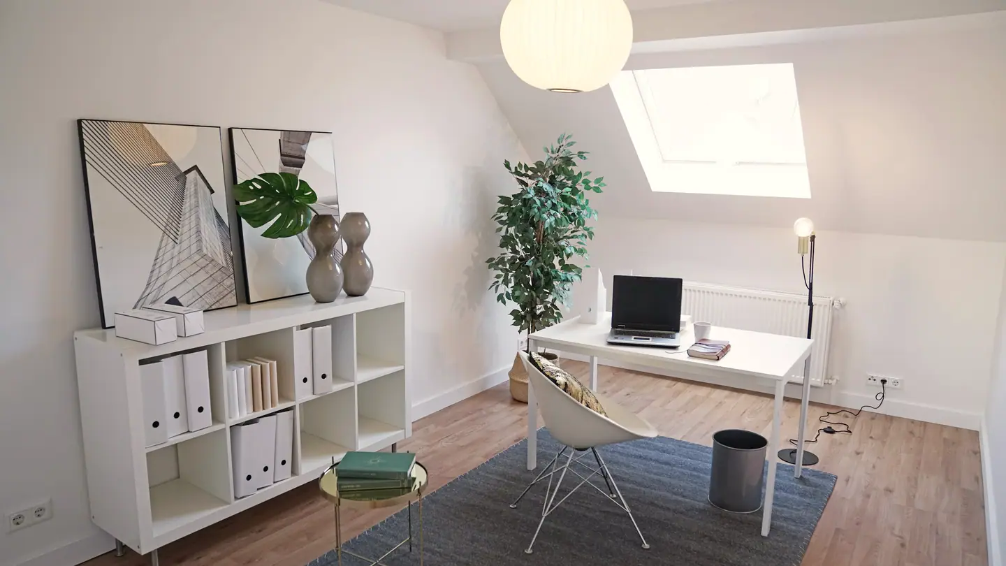 Arbeitszimmer mit Schreibtisch unter dem Dachfenster